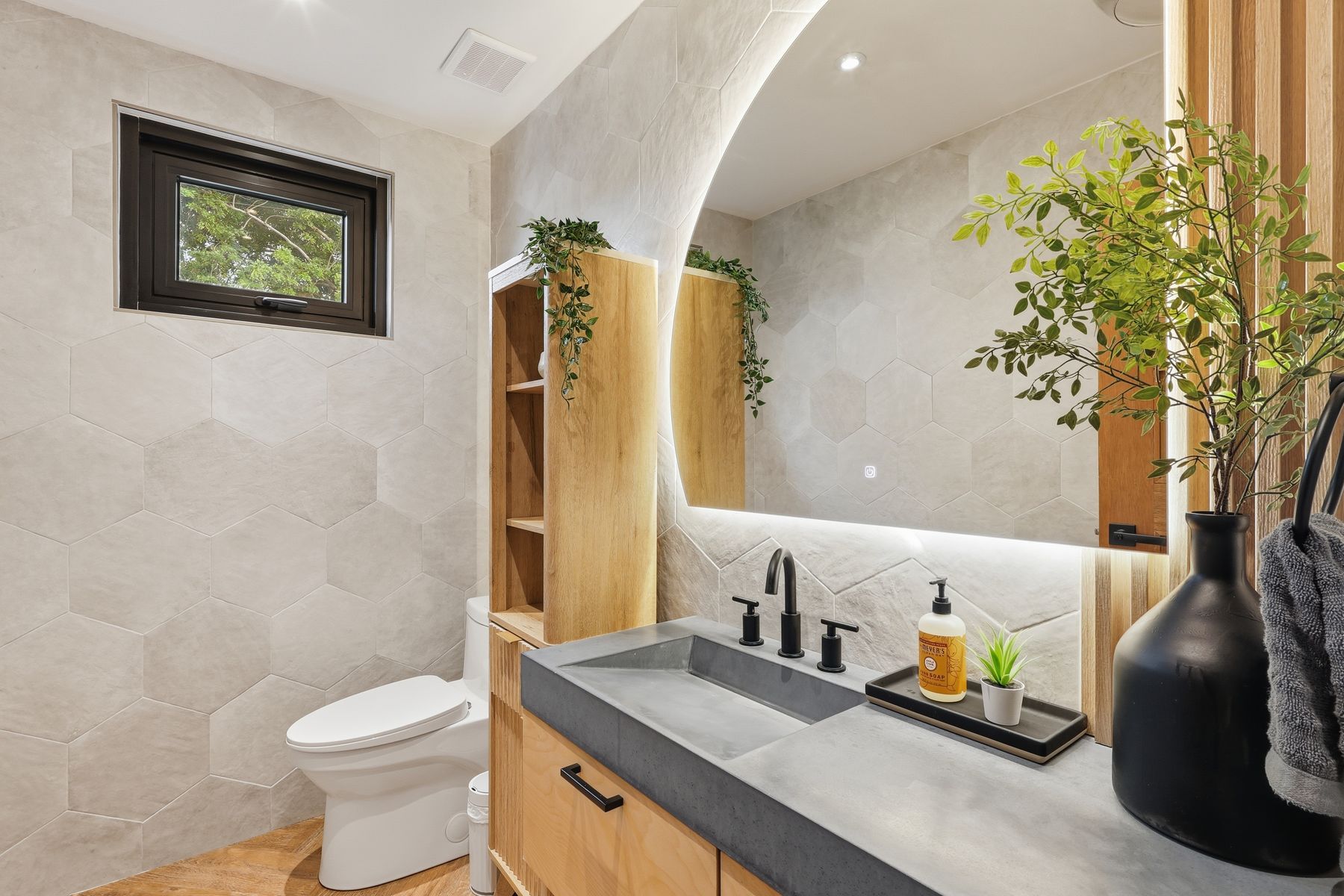 Designer bath with arched niche, wood vanity and matte-black fixtures — Bou Photography