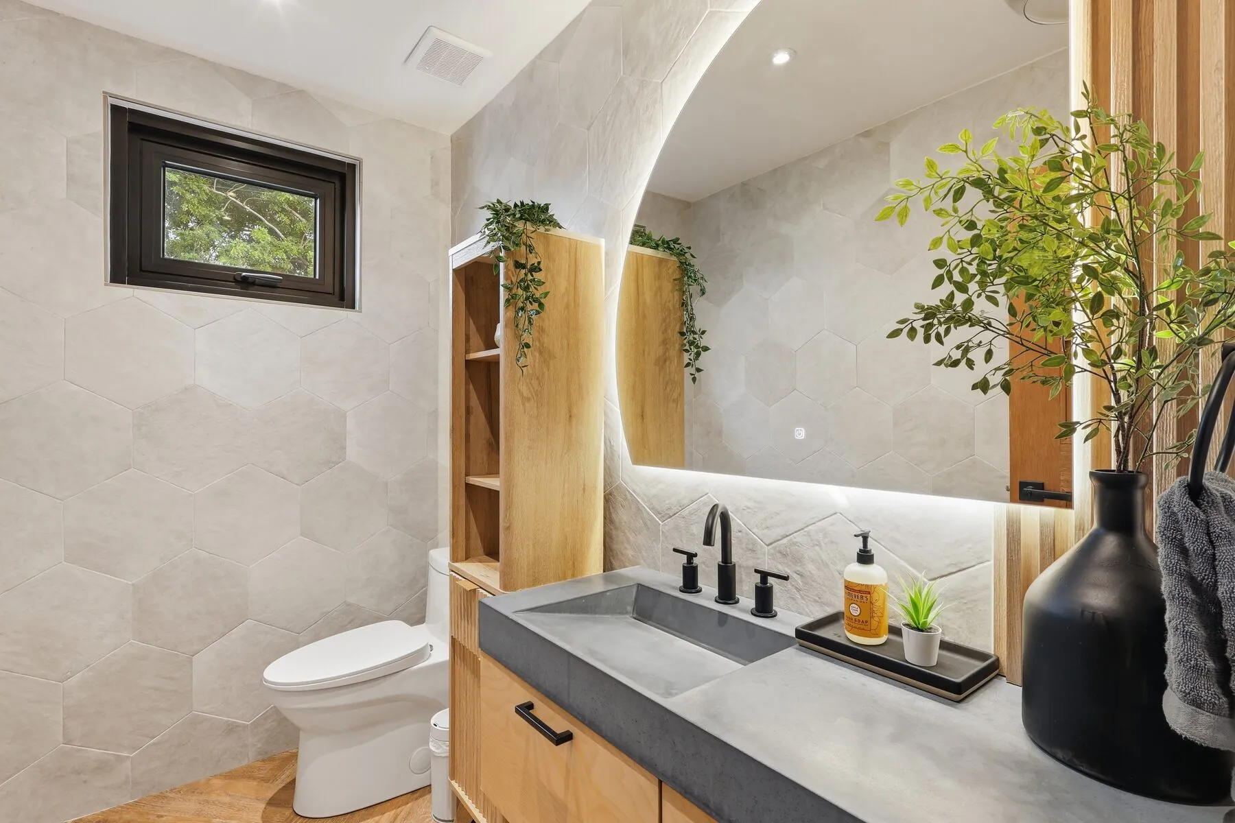 Designer bath with arched niche, wood vanity and matte-black fixtures — Bou Photography